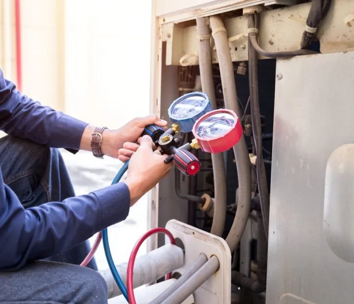 A skilled technician holding a pressure regulator gauge of a heating system